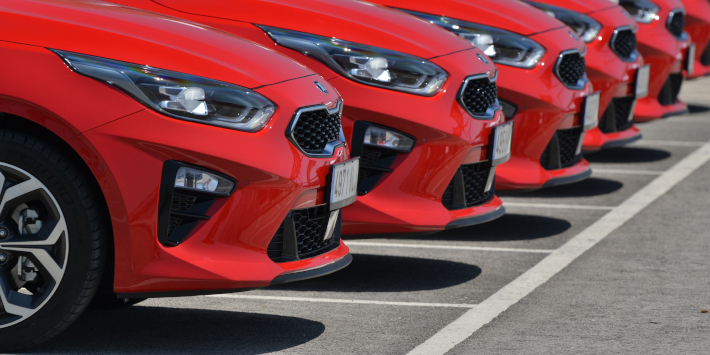 Red compact cars Kia Ceed parked on the parking before the drives.